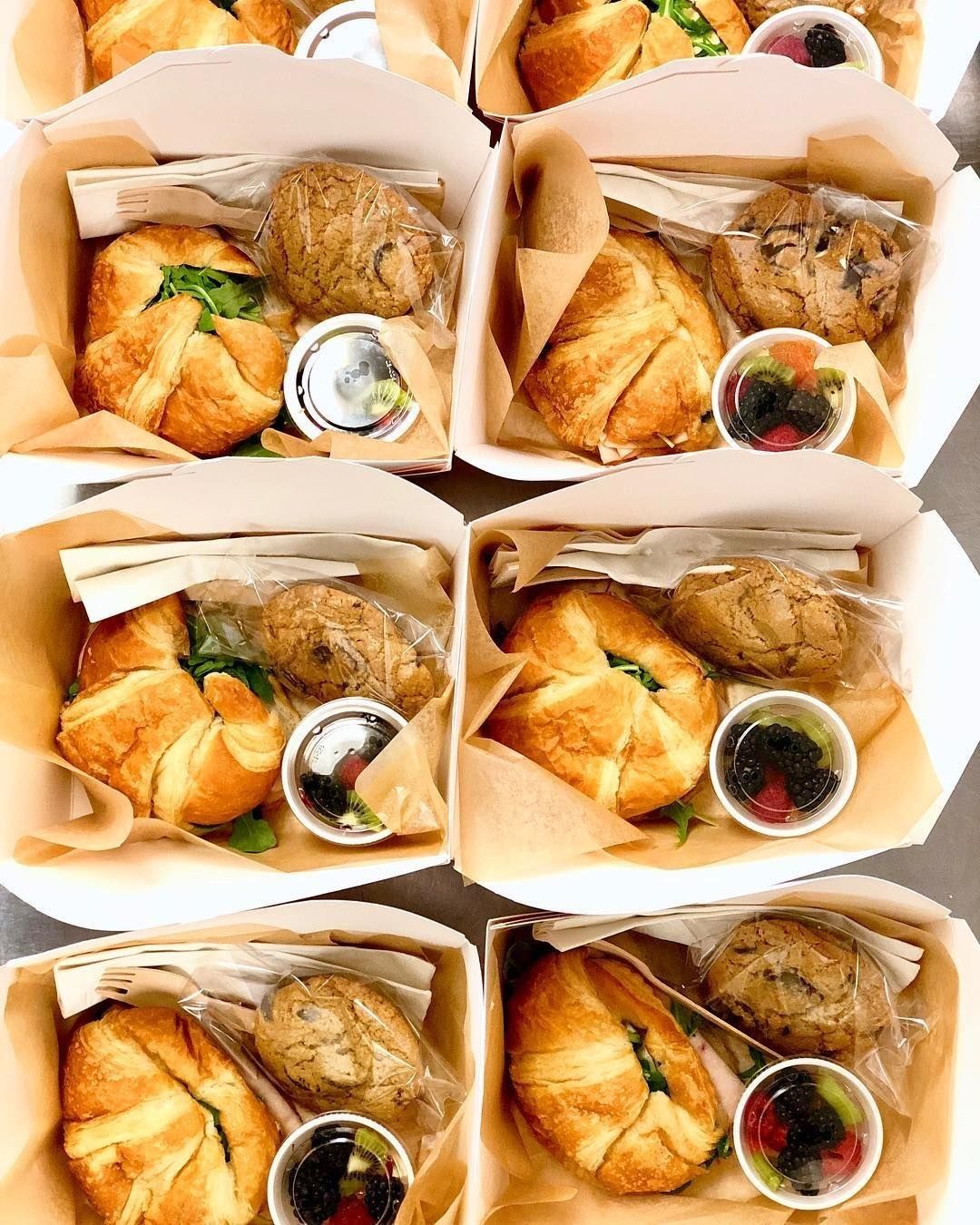 Cajas de box lunch con sándwich, fruta y postre listas para entregar
